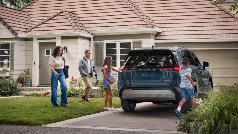 family with Toyota RAV4 in driveway