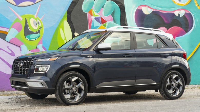Black Hyundai Venue parked in front of a colorful wall