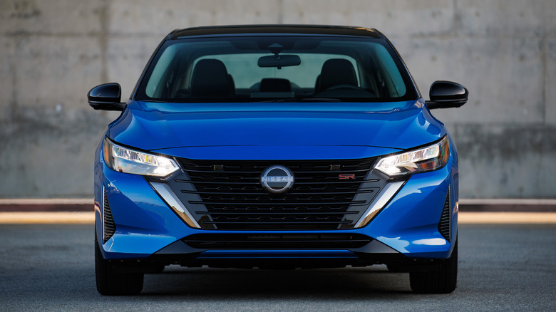 Frontal photo of blue Nissan Sentra in front of a concrete wall