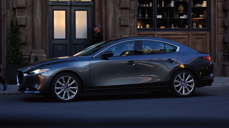 Gray Mazda3 sedan parked in front of a store