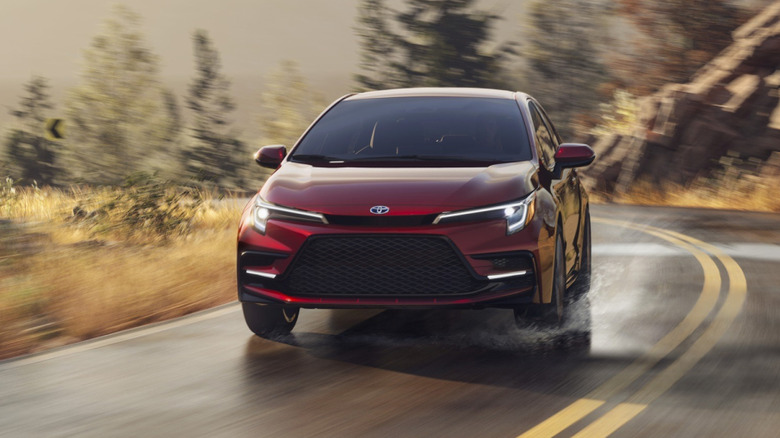 Red Toyota Corolla Hybrid cornering on a wet road
