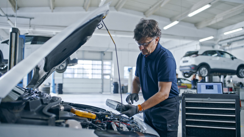 Mechanic checking a car engine in a garage