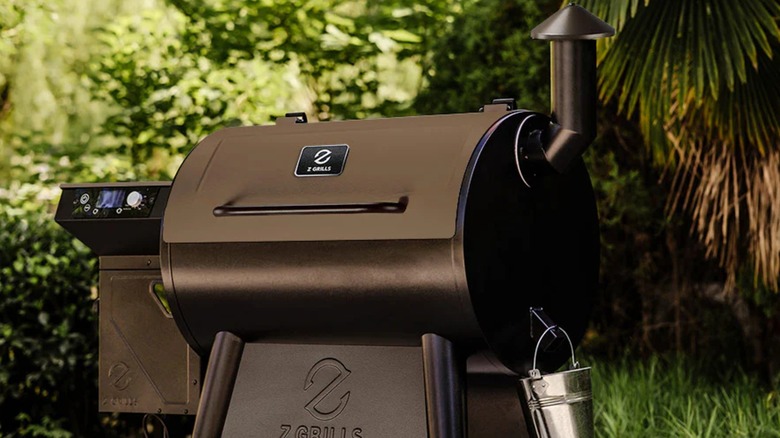 Z Grills pellet grill and smoker in a garden with trees in the background
