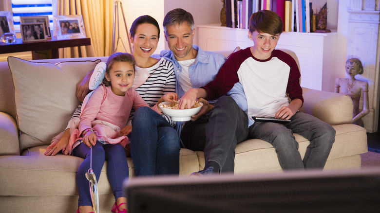 a family of four watching TV together