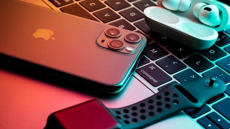 iPhone, Apple Watch, and Air Pods seen on a laptop keyboard
