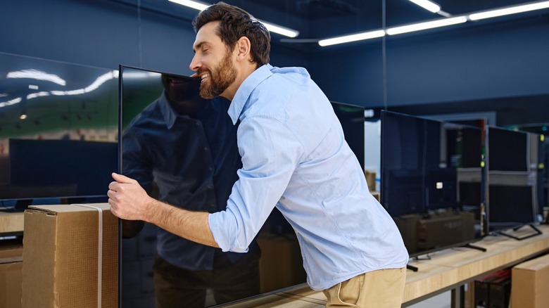 Man embracesTV with excitement