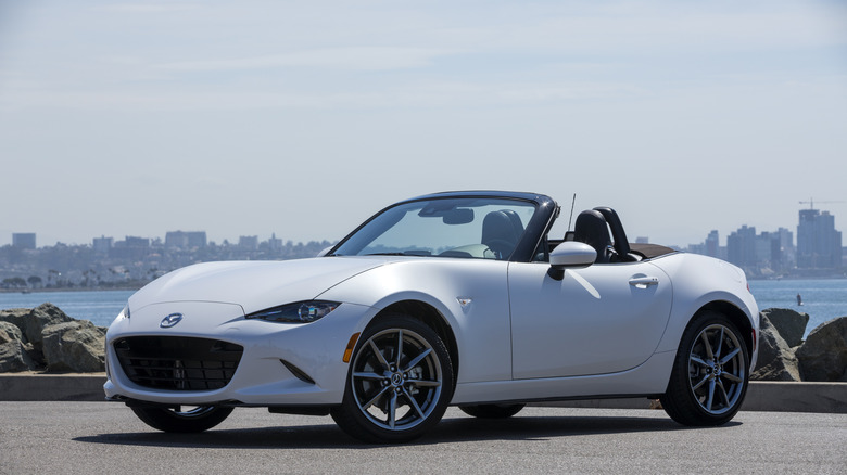 Mazda ND MX-5 Miata parked in front of seaside, front-left 3/4 view