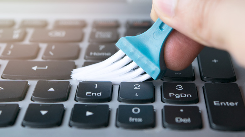 Closeup of brush moving along keyboard. 