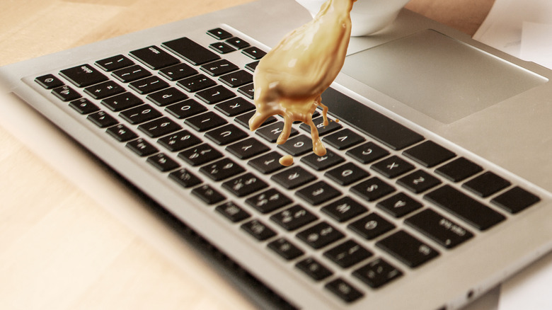 Someone spilling coffee on a laptop. 