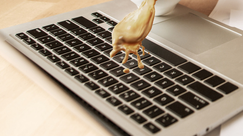 Someone spilling coffee on a laptop.