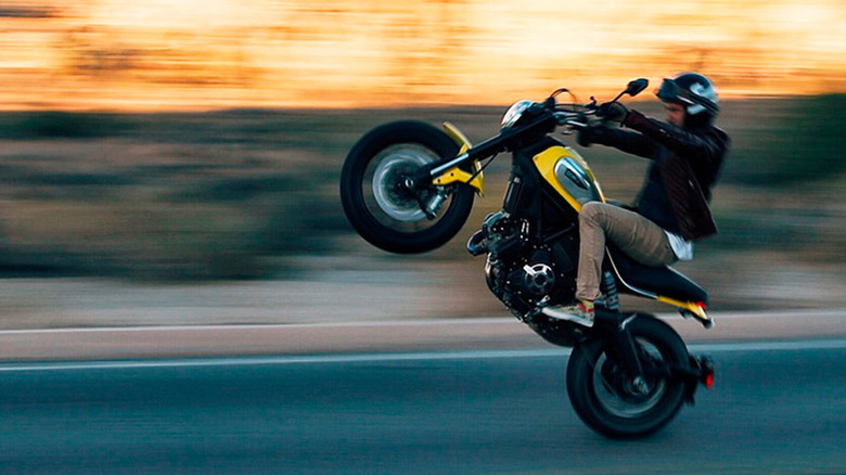 Person doing wheelie on Ducati Scrambler