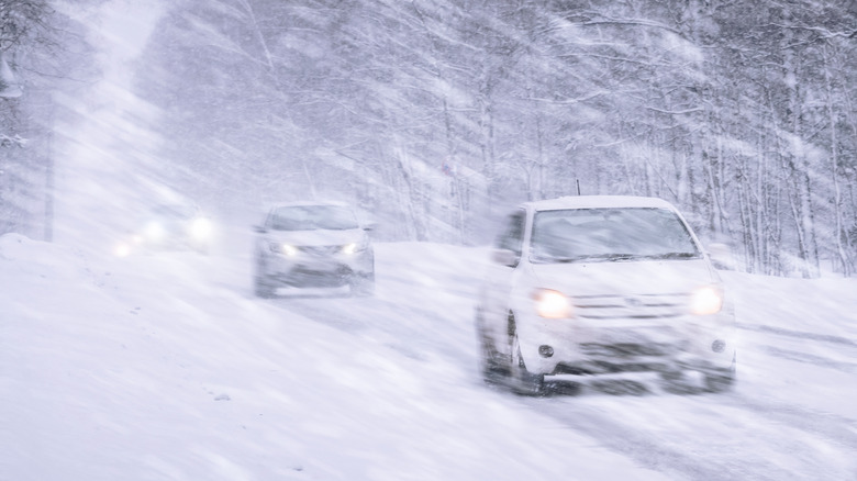 Cars driving in a winter snow storm.