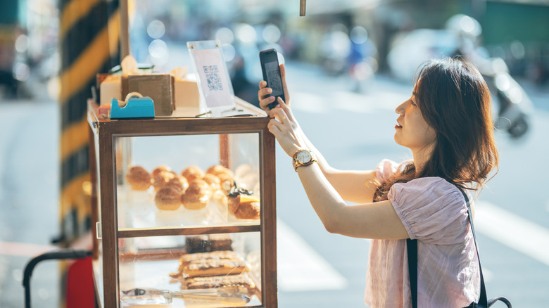 A person attempting to make a payment with their phone.