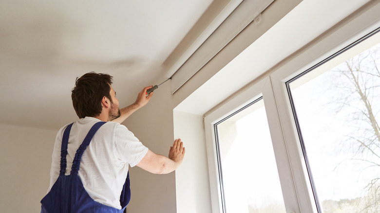 Someone repairing window blinds