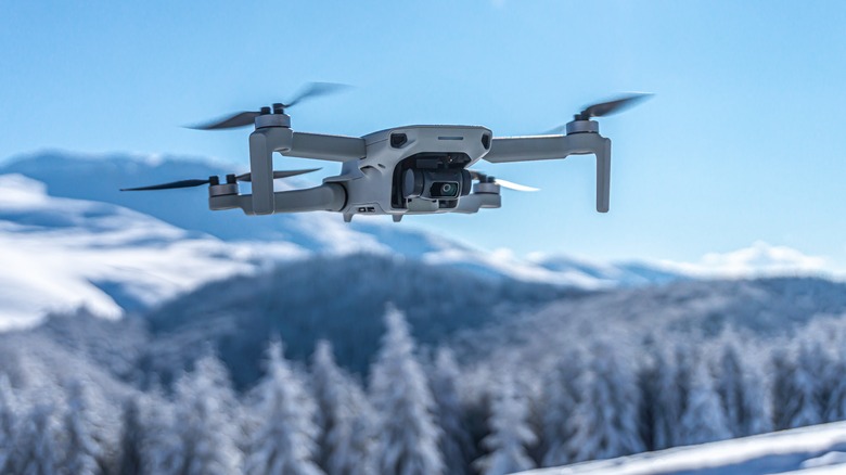 Quadcopter flying over snowy mountains
