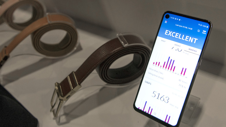 Welt smart belt on display besides its app