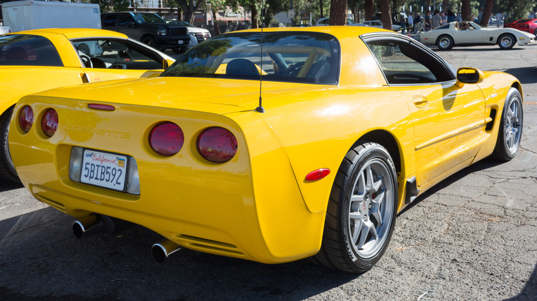 Rear 3/4 view of yellow C5 Corvette parked at car show.