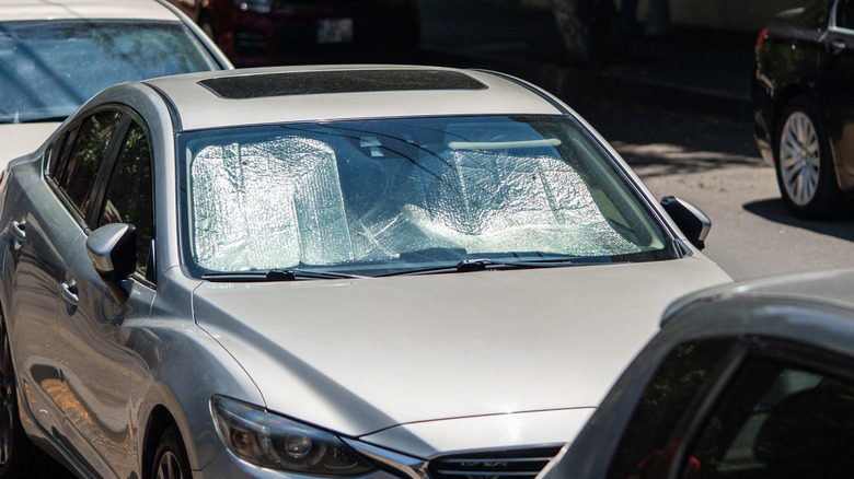 Car parked with a reflective sunshade
