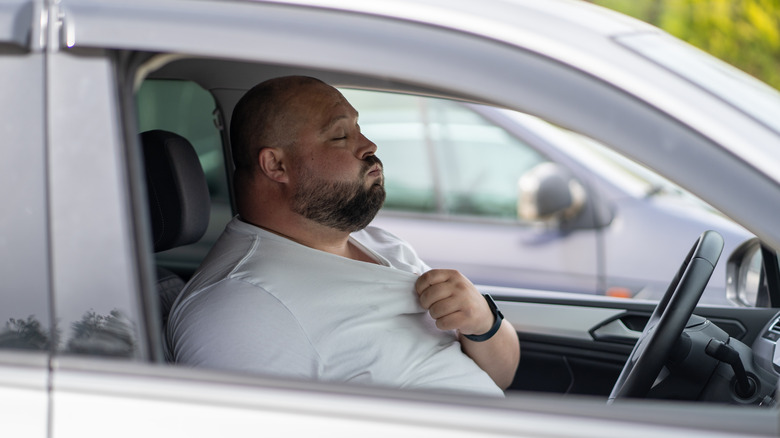 Driver in an uncomfortably hot car cabin