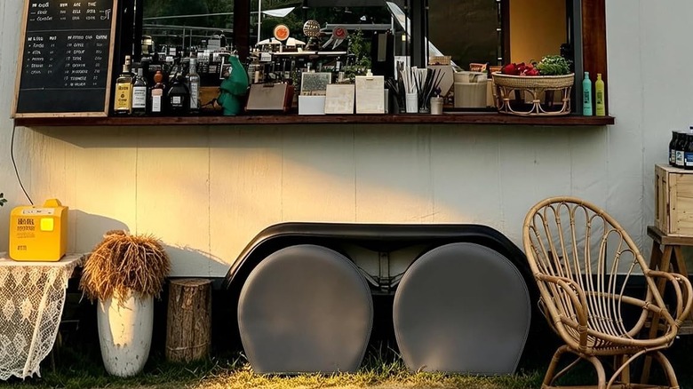 A food truck, window open and ready for business, with covered tires.