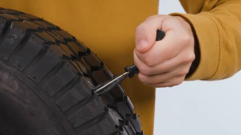 a person plugging a tire with a kit similar to the one described here