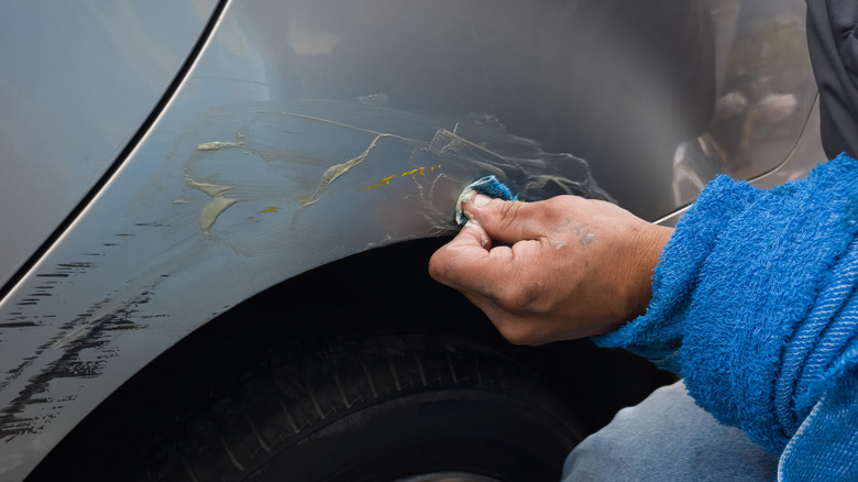 Auto mechanic repairing scratches on a car