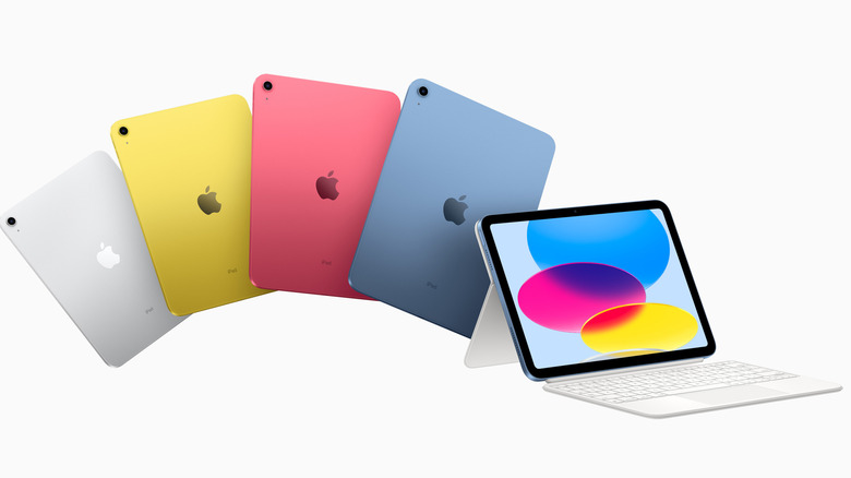 Five Apple iPads in different colors, including one with a keyboard attached.