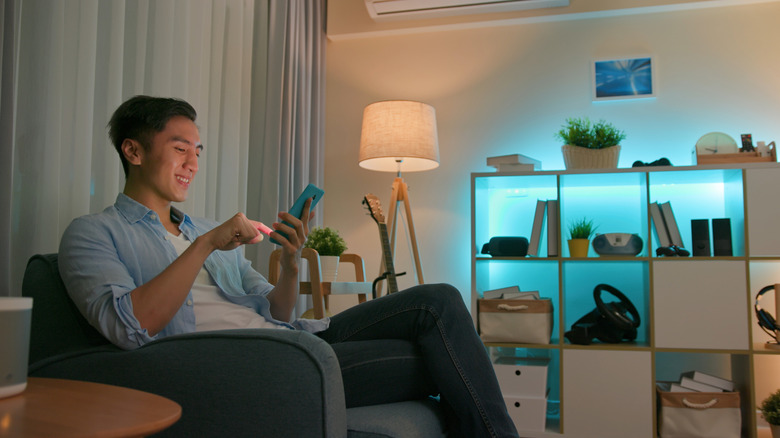 Man using a smartphone to control smart lighting