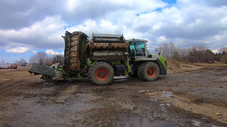 A CLAAS Cougar folding up its mowing decks for transport