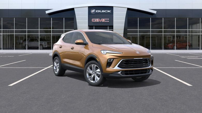 A Copper Buick Encore GX parked outside of a dealership