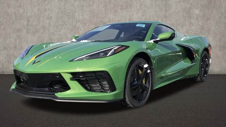 A Roswell Green Chevy Corvette parked by a gray building