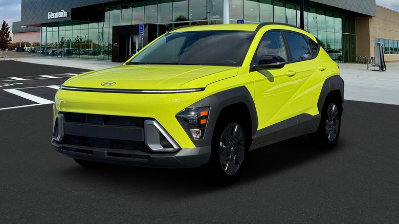 A yellow Hyundai Kona parked outside of a dealership