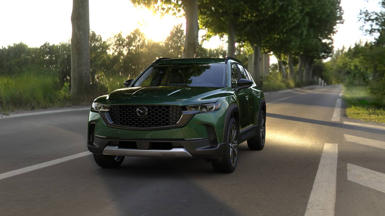 A Cypress colored CX-50 on a road at sunset