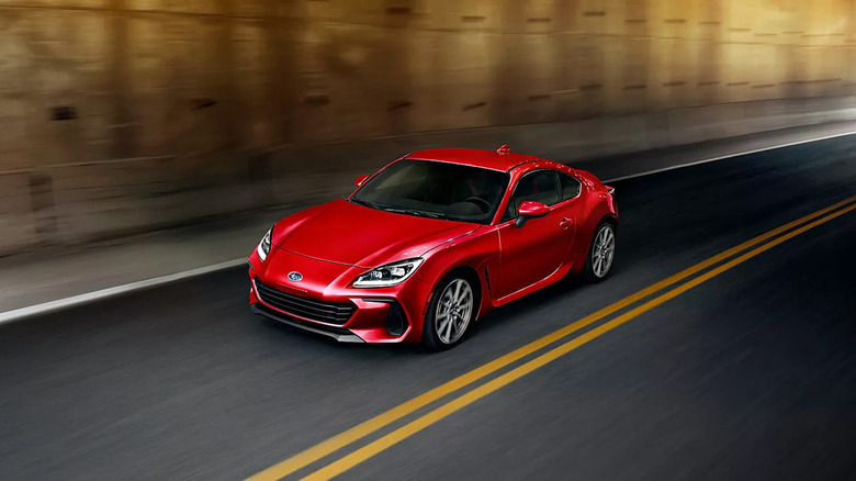 A red Subaru BRZ driving in a tunnel