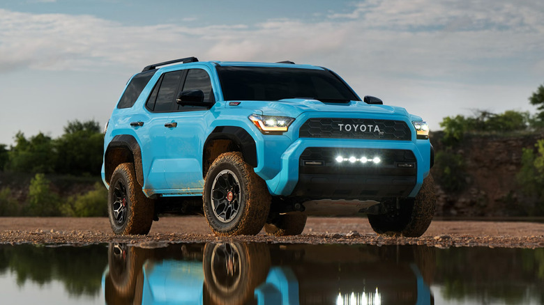 A bright blue Toyota 4Runner parked next to some water