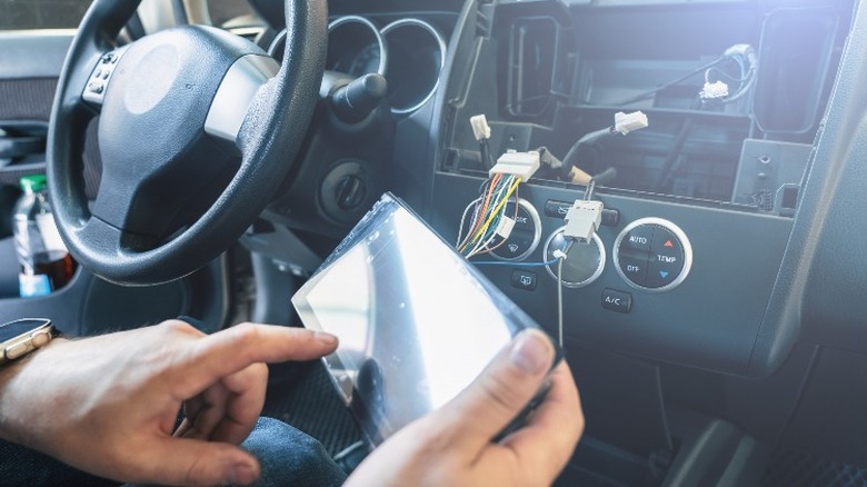 Person replacing car stereo