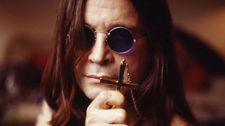 Close up of Ozzy Osbourne holding a cross