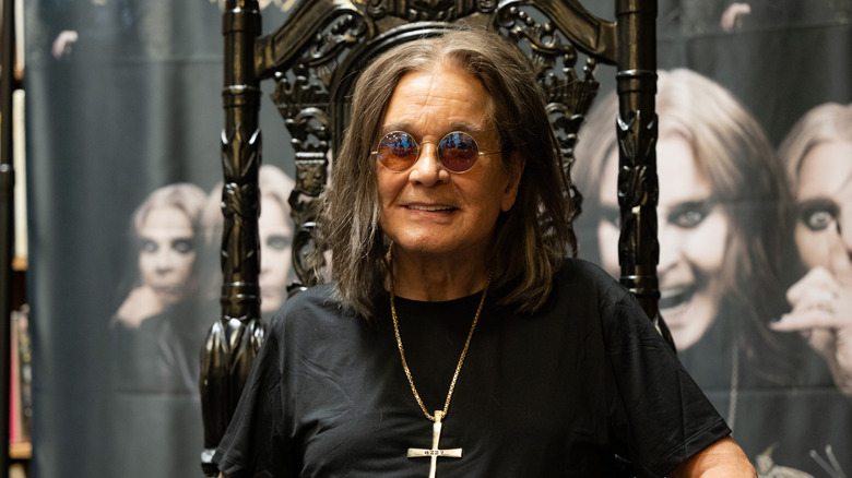 Ozzy Osbourne sentado en una silla de espalda de aspecto gótico