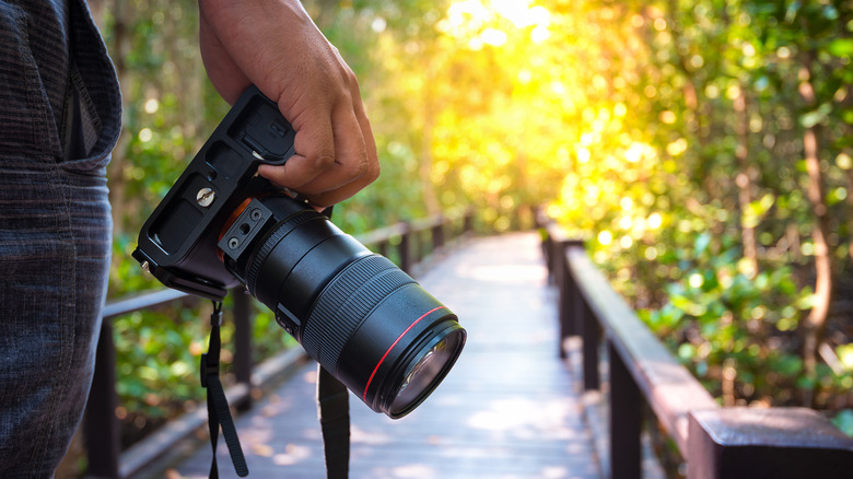 Man holding his DSLR Camera by his side