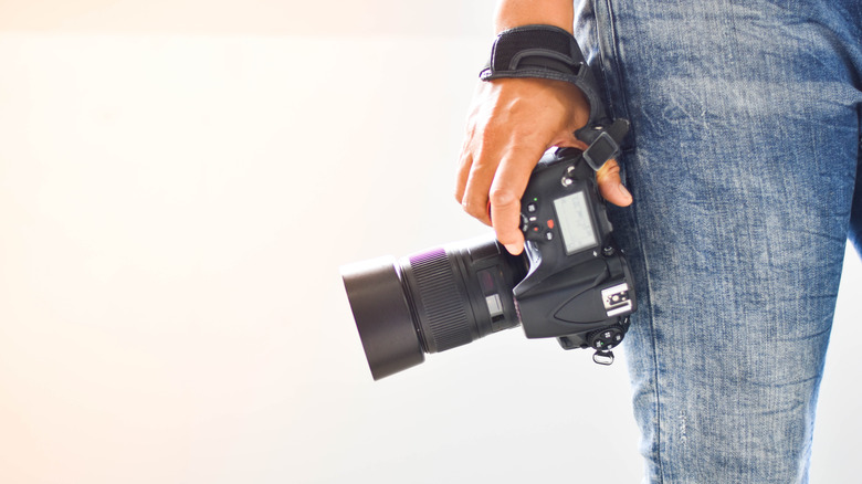 photographer holding a DSLR by his / her side