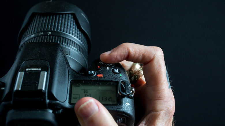finger on the shutter button of camera 