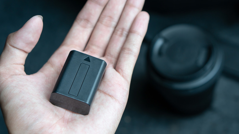 a camera battery in someone's hand