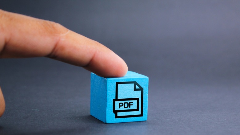 finger on blue cube with PDF icon