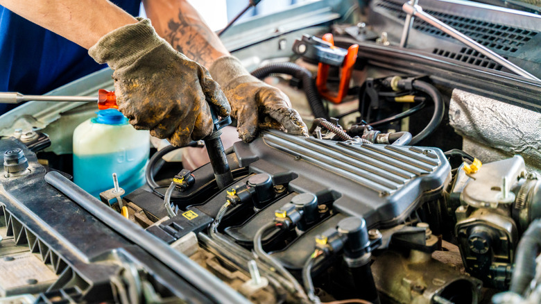 Person working on the engine of a car