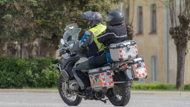 Riders on overloaded touring motorcycle.