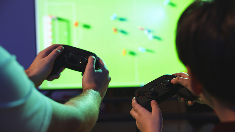 two people playing a game using gaming controllers in front of a TV