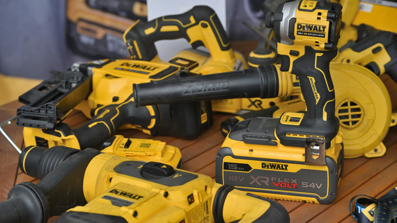 A selection of DeWalt tools on a wood table.