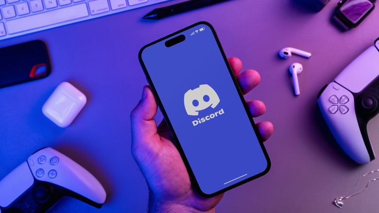 Discord app on a phone with DualSense controllers next to it