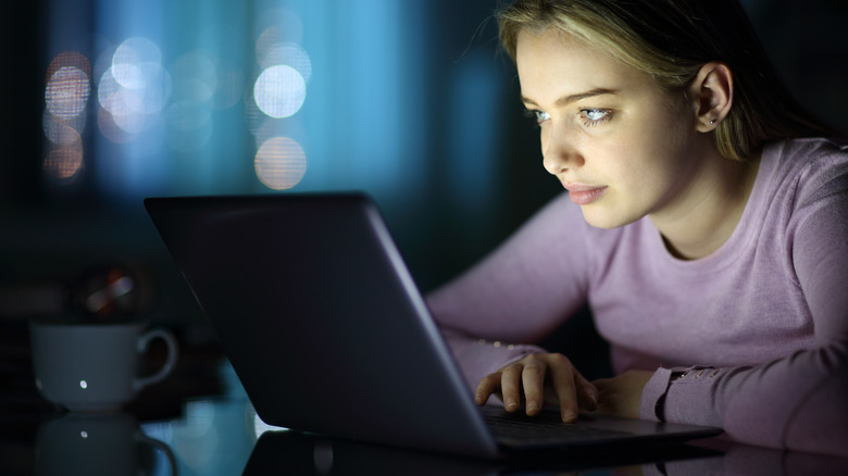 woman using laptop at night
