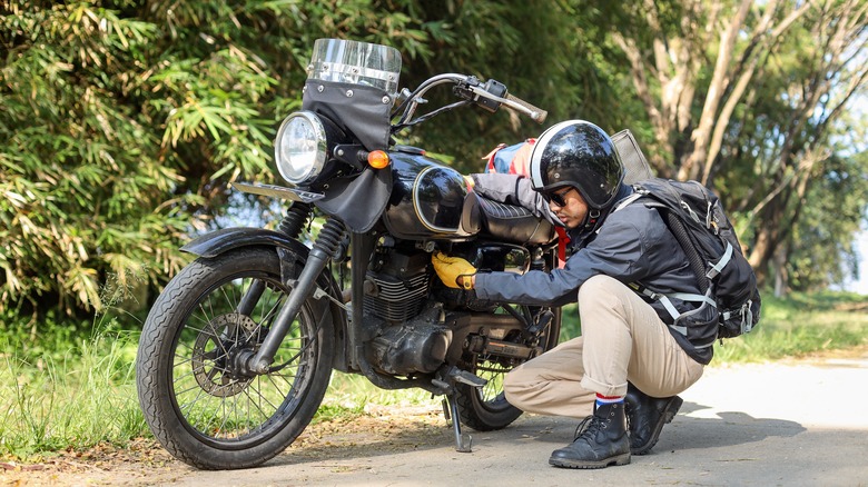 man parking a motorcycle outdoors